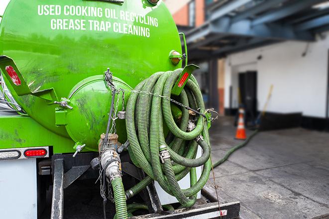 a technician pumping a grease trap in a commercial building in Kansas